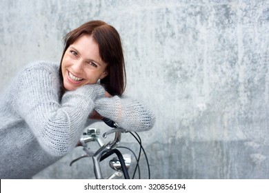 Portrait Of A Middle Aged Woman Smiling And Leaning On Bicycle 