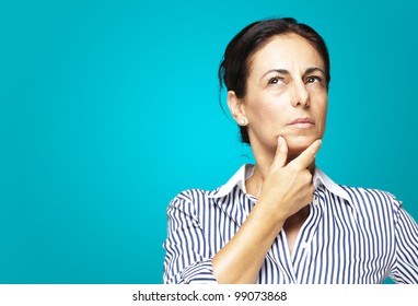 Portrait Of A Middle Aged Woman Thinking Against A Blue Background