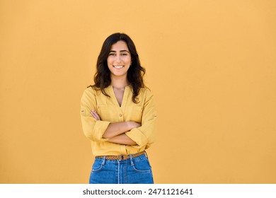 Portrait of middle eastern Israel girl student standing with crossed arms isolated on yellow background. Smiling young Arabian Indian woman, businesswoman, business lady looking at camera, copy space - Powered by Shutterstock