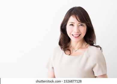 Portrait Of Middle Woman In Front Of White Wall