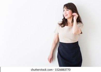 Portrait Of Middle Woman In Front Of White Wall