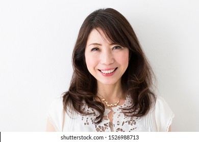 Portrait Of Middle Woman In Front Of White Wall