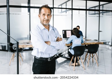 Portrait Of Middle-aged Hispanic Man Standing With Arms Crossed In Office In Latin America