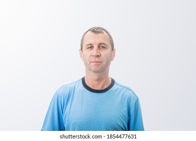 Portrait of a middle-aged man against a white wall background looking to camera. Serious expresion of  mature man over  white background . Middle-aged man front view. - Powered by Shutterstock