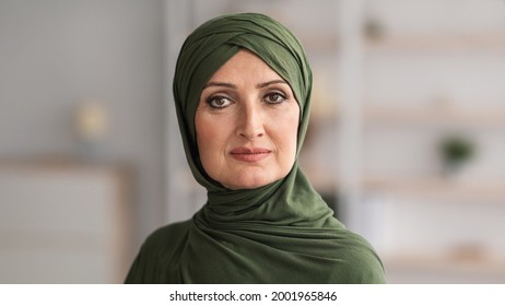 Portrait Of Middle-Aged Muslim Female Wearing Hijab Looking At Camera Posing Standing Indoors. Beauty Of Middle-Eastern Women Concept. Headshot Of Senior Arab Lady. Panorama