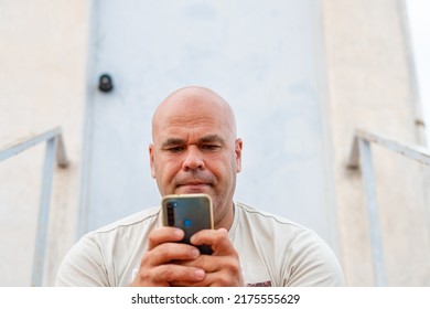 Portrait of a middle-aged Spanish man, using a mobile phone, outside.  - Shutterstock ID 2175555629