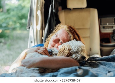 Portrait of middle-aged woman hugging her cockapoo puppy pet while sitting in van camper car vehicle during road trip. Best friend. Enjoying free lifestyle, vacation, freedom. Travel with pets - Powered by Shutterstock