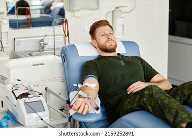 Portrait Of Military Man Giving Blood While Laying In Chair At Blood Donation Center, Copy Space