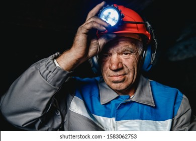 Portrait Miner Coal Man In Helmet With Lantern In Underground Mine. Concept Industrial Engineer.