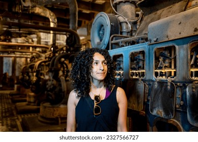 Portrait of a mixed race woman smiling while posing inside an abandoned factory. - Powered by Shutterstock