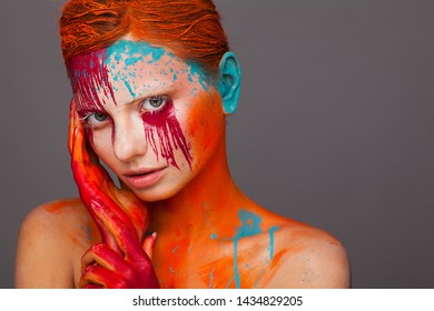 Portrait of a model in an expressive creative style using an unusual make-up. Studio beauty shooting