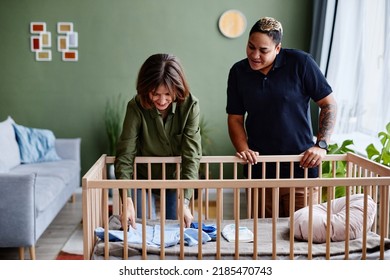 Portrait Of Modern Gay Couple Expecting Baby And Preparing Crib, Same Sex Family At Home, Copy Space