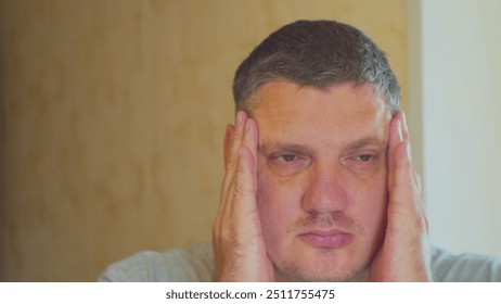 Portrait of a modern man. Stress and its impact on human life. Upset man massages his head to restore his emotional state after a hard day at work. - Powered by Shutterstock