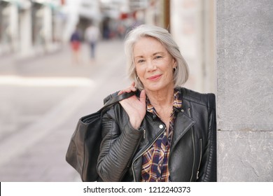  Portrait of modern senior woman in town wearing leather jacket                              