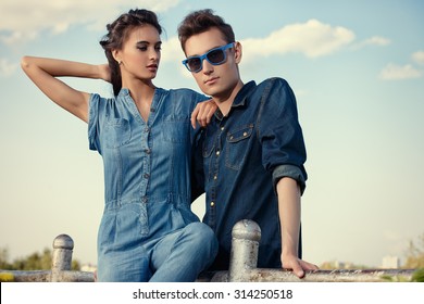 Portrait Of A Modern Young People Wearing Jeans Clothes Over Blue Sky. Fashion Shot.