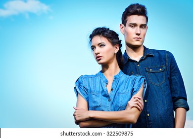 Portrait Of A Modern Young People Wearing Jeans Clothes Over Blue Sky. Fashion Shot.