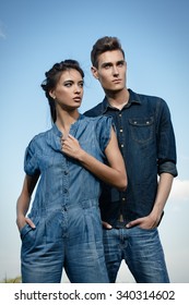 Portrait Of A Modern Young People Wearing Jeans Clothes Over Blue Sky. Fashion Shot.