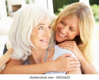 Portrait Of Mother And Adult Daughter Relaxing On Sofa