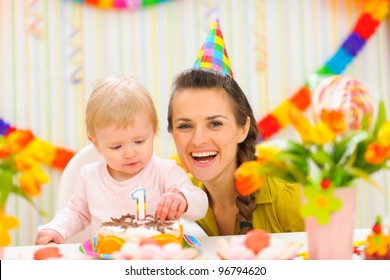 Portrait of mother and baby with birthday cake