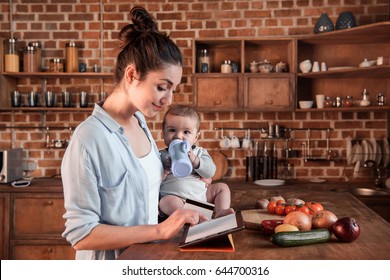 Portrait of mother and baby boy shopping online with digital tablet and credit card - Powered by Shutterstock