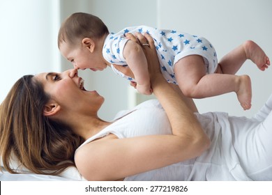 Portrait Of Mother And Baby Playing And Smiling At Home.