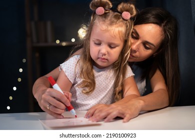 Portrait Of Mother And Daughter Drawing At Home At Night. Woman Help Child To Draw. Girl From Elementary Class, Back To School. Copy Space