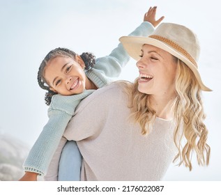 Portrait of a mother and daughter having fun and bonding on a beach vacation together. Happy adopted black child being playful and cute with her caucasian foster mom. Parent and kid enjoying summer - Powered by Shutterstock