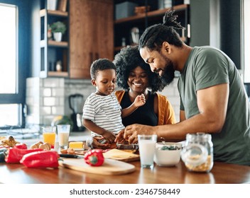 Portrait of mother, father and son preparing and eating breakfast in the kitchen at home - Powered by Shutterstock