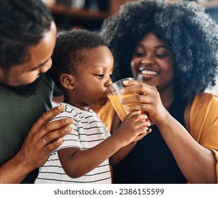 Portrait of mother, father and son  preparing and eating breakfast, child drinking juice in the kitchen at home - Powered by Shutterstock