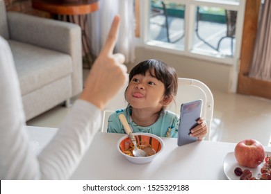 Portrait Of A Mother Get Angry With Stubborn Kid Using Mobile Phone