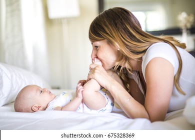 A Portrait of mother with her 3 month old baby in bedroom - Powered by Shutterstock