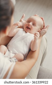 Portrait Of A Mother With Her 3 Months Old Baby. Mother Holding Head Of Her Newborn Son In Hands. The Baby On Hands At Mum. Loving Mother Hand Holding Cute Sleeping Newborn Baby.home Portrait. Love