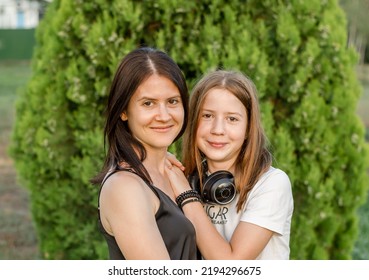 Portrait Of A Mother With Her Daughter In Nature. Mom Hugs Her Daughter