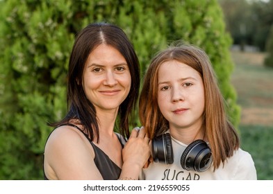 Portrait Of A Mother With Her Daughter In Nature. Mom Hugs Her Daughter