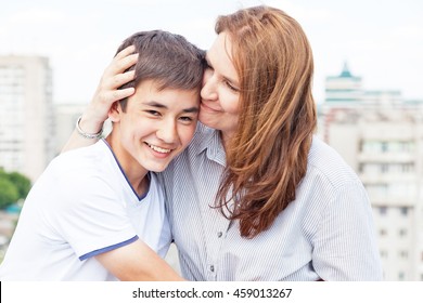 Portrait of a mother with her son teenager. Tenderness, love, multinational family