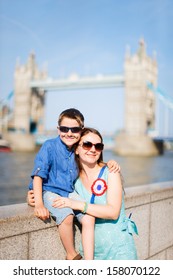 Portrait Of A Mother And Son In Front Of Tower Bridge In London
