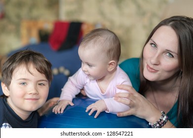 Portrait Of Mother With Two Children At Home