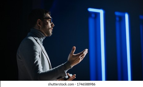 Portrait of Motivational Speaker Wearing Glasses, Talking about Happiness, Self, Success and How Better More Productive Self. Tech Startup Presenter Pitching. Cinematographic Light - Powered by Shutterstock