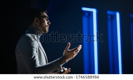Portrait of Motivational Speaker Wearing Glasses, Talking about Happiness, Self, Success and How Better More Productive Self. Tech Startup Presenter Pitching. Cinematographic Light
