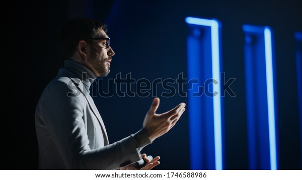 Portrait of
Motivational Speaker Wearing Glasses, Talking about Happiness,
Self, Success and How Better More Productive Self. Tech Startup
Presenter Pitching. Cinematographic
Light
