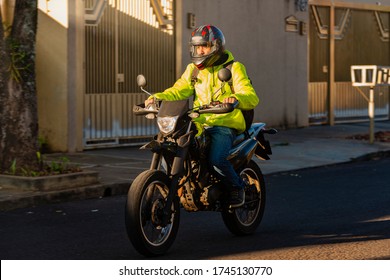 Portrait Of Motorcycle Delivery Man Riding To His Destination.