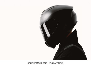 Retrato de un motociclista posando con un casco negro sobre un fondo blanco.