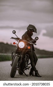 Portrait Of Motorcyclist Woman Using Mobile Phone, Smartphone During Stop. Young Driver Biker Uses A Navigator.