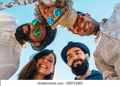 Portrait Of Multi Ethnic Friends Standing In Circle And Looking Down At Camera