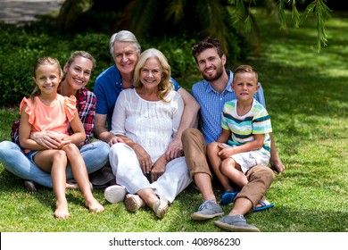 Portrait of multi generation family relaxing on grass at yard - Shutterstock ID 408986230