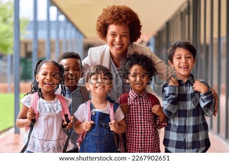 Portrait Of Multi-Cultural Elementary School Pupils With Female Teacher Outdoors At School