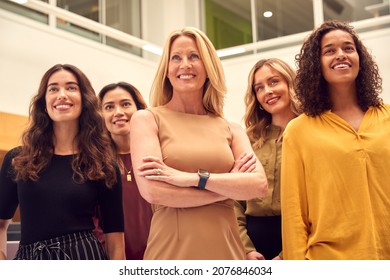 Portrait Of Multi-Cultural Female Business Team Standing In Modern Open Plan Office