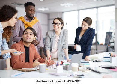 Portrait of multi-ethnic business team smiling cheerfully while discussing creative project during meeting in sunlit office - Powered by Shutterstock