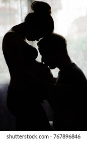 Portrait of multi-ethnic couple married and in love in silhouette by the window