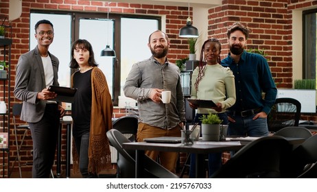 Portrait of multiethnic group doing teamwork on presentation, planning research project to create business partnership. People working on professional report with data. Tripod shot.